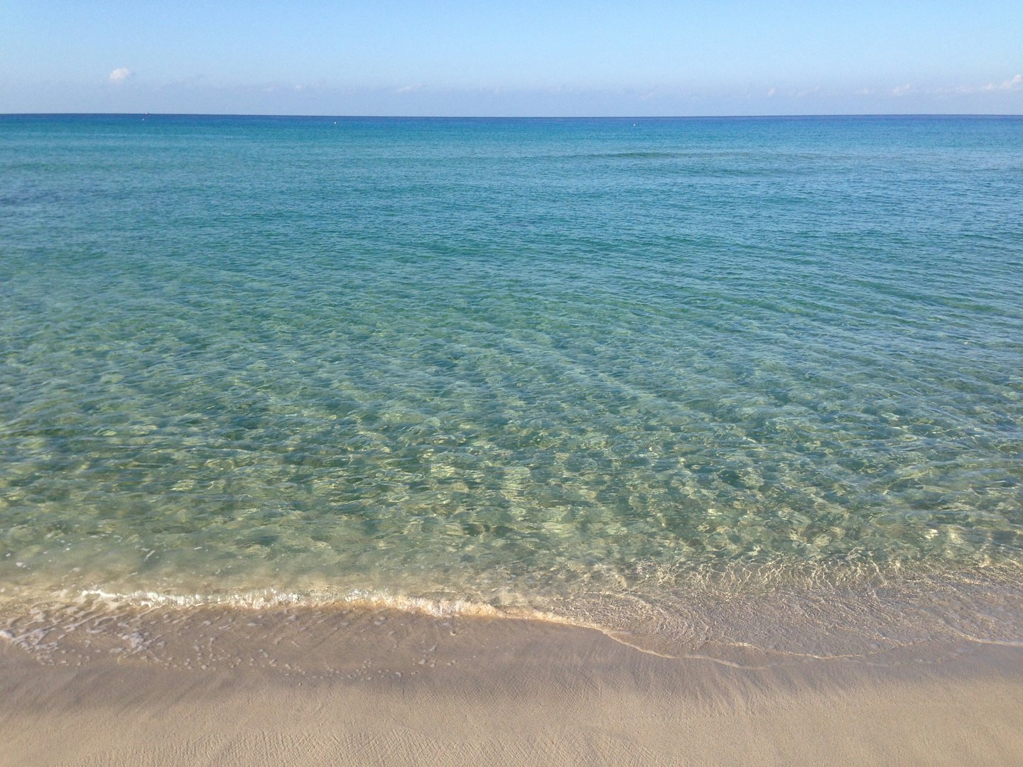 Gentle waves wash over the sandy shore of a beach.